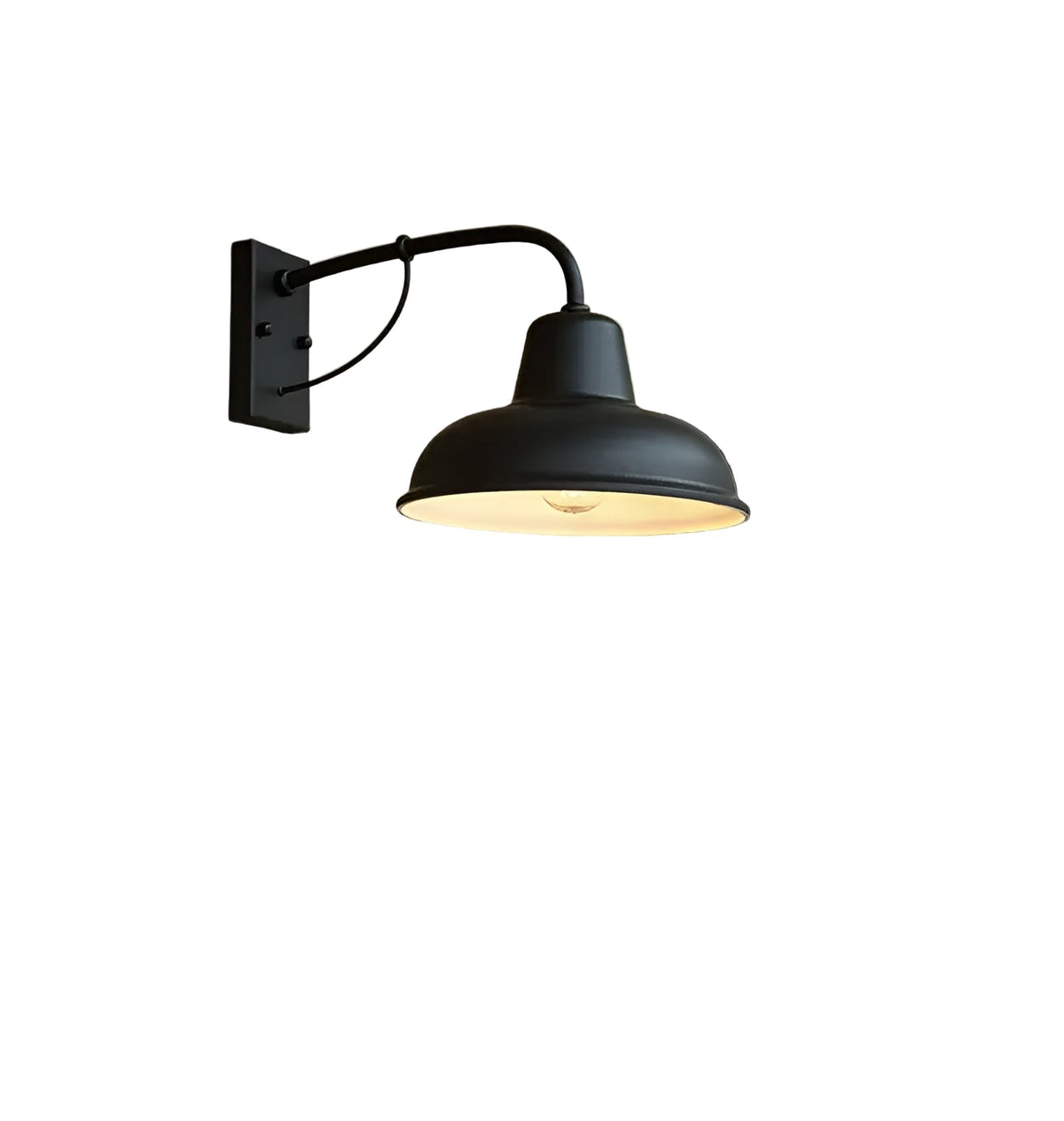 Matt black barn-style wall light with curved arm, rectangular backplate and domed shade with a pale interior, shown on a white background. 1