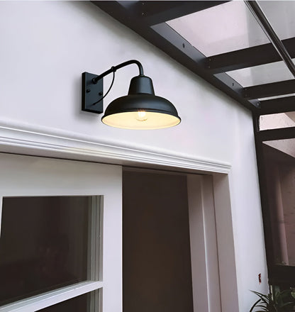 Black wall light switched on above a white door with moulded trim, under a glazed canopy with dark beams. 4