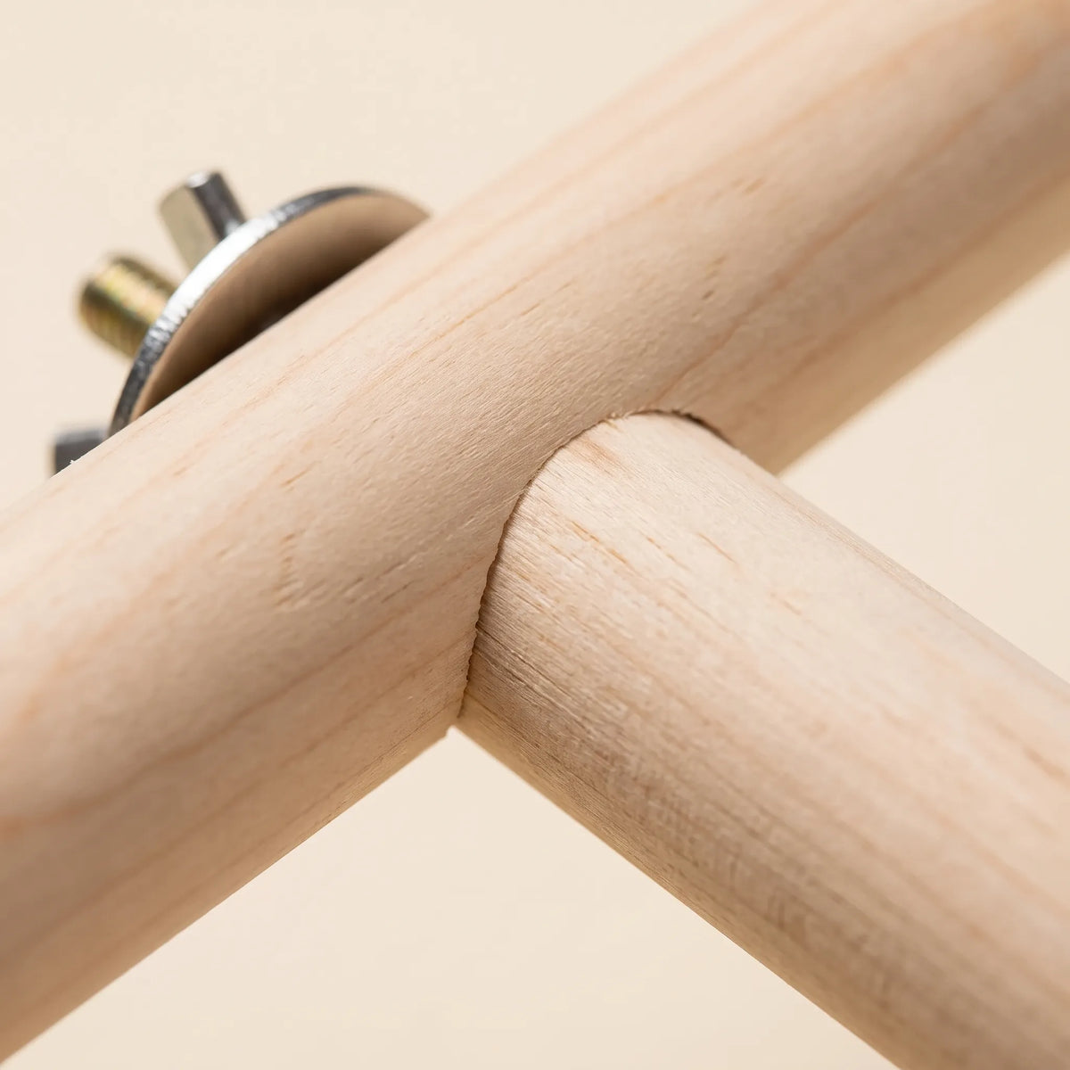 Close-up of the joint where the wooden bar meets a leg, with a metal washer and threaded bolt beside it. 3