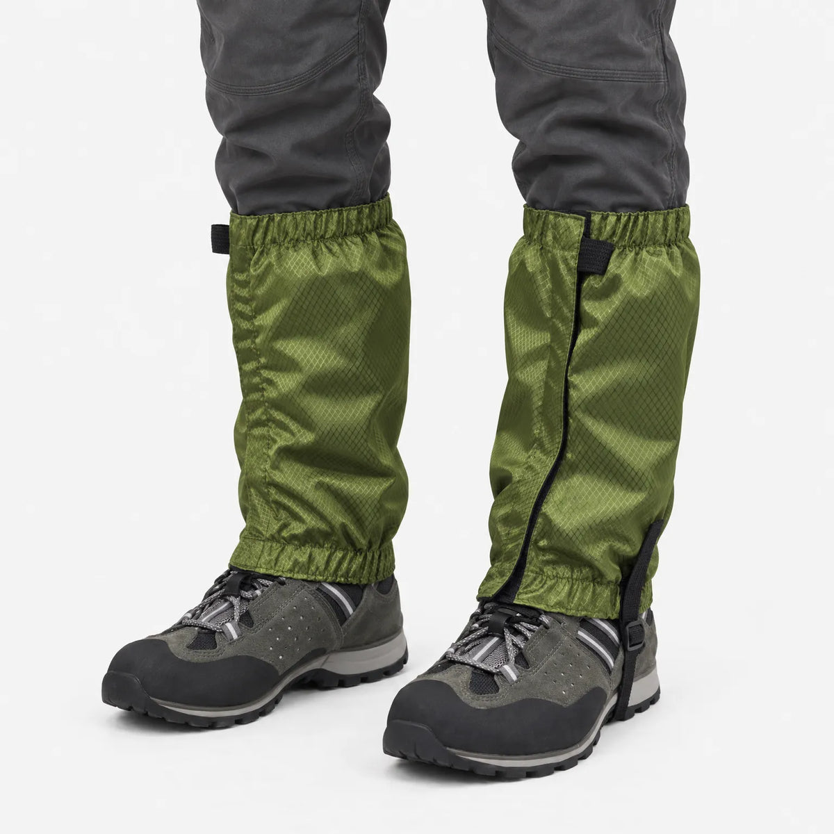 Olive green ripstop gaiters with elastic tops and hems, worn over grey hiking boots, shown against a plain white background. 2