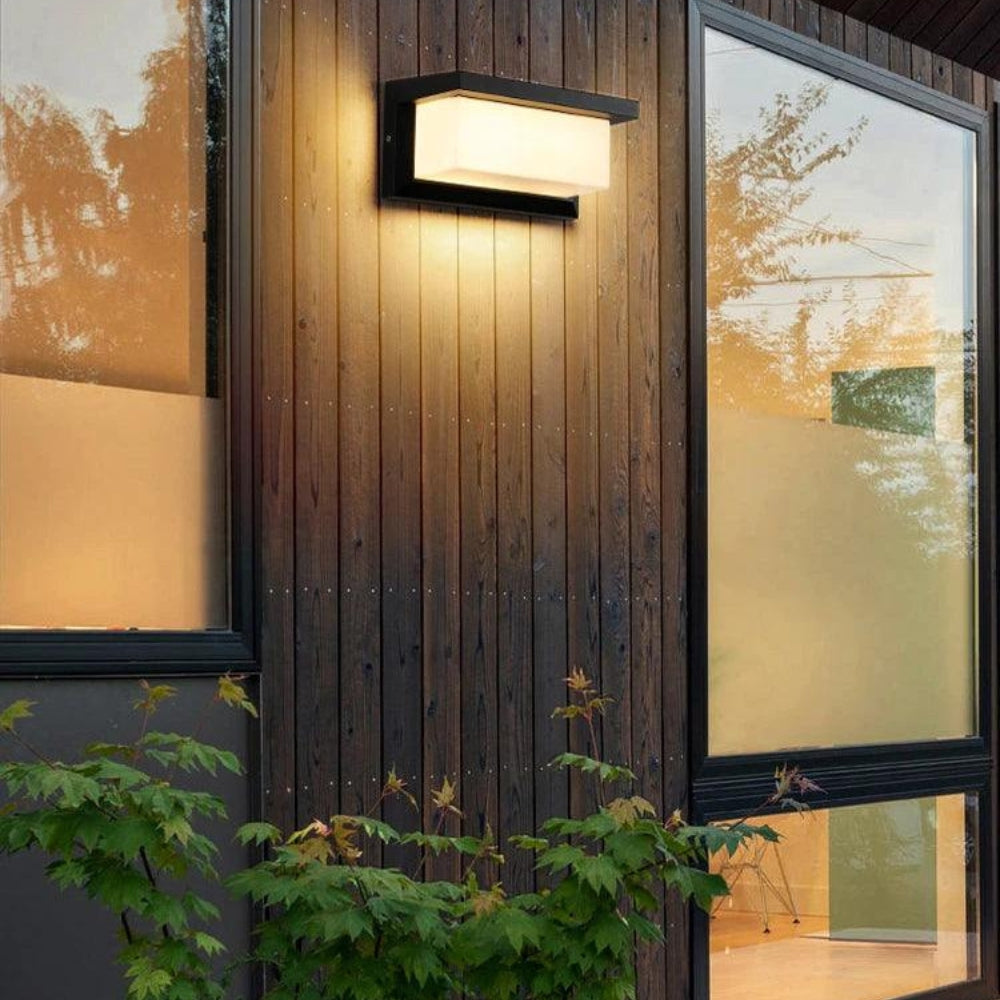 Light fixed to dark vertical wood cladding between two large windows, shining warm light up and down 5