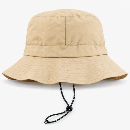 Sand-coloured bucket hat with a wide stitched brim and a black-and-white drawcord hanging below it, shown on a plain white background. 7