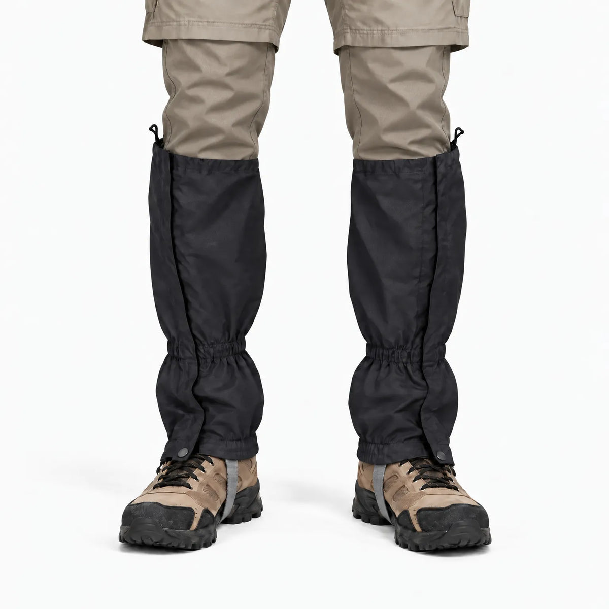 Front view of black gaiters with side fastening, worn over khaki trousers and brown walking boots against a white background. 9