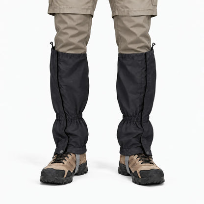 Front view of black gaiters with side fastening, worn over khaki trousers and brown walking boots against a white background. 9