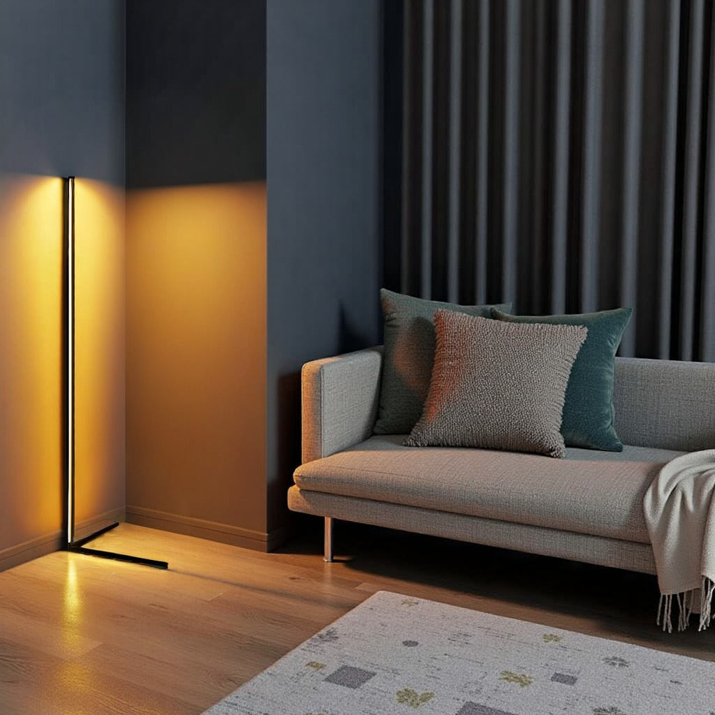 Lamp casting golden light on a blue-grey wall beside a sofa with cushions and a fringed throw 11