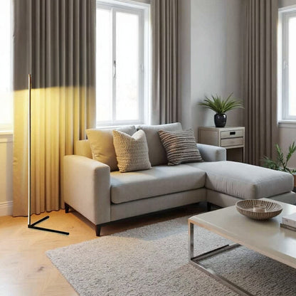 Black lamp with a V-shaped foot lighting beige curtains beside a light grey corner sofa 10