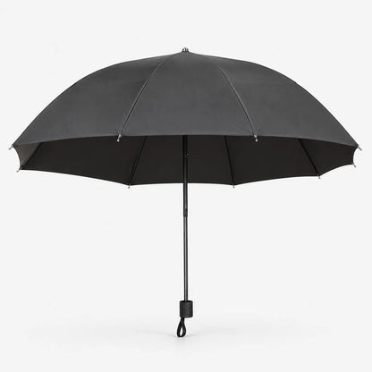 Open umbrella in dark grey on a white background, side view with the black canopy lining and wrist loop on the handle. 3