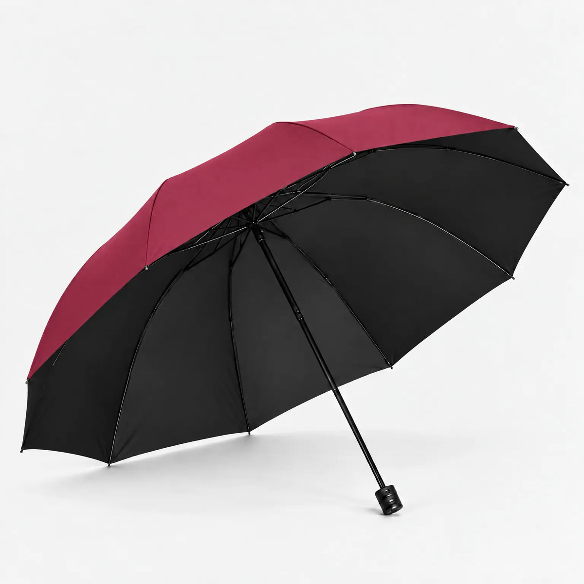 Open burgundy umbrella seen from below at an angle, with the black underside lining and ribs on a white background. 6