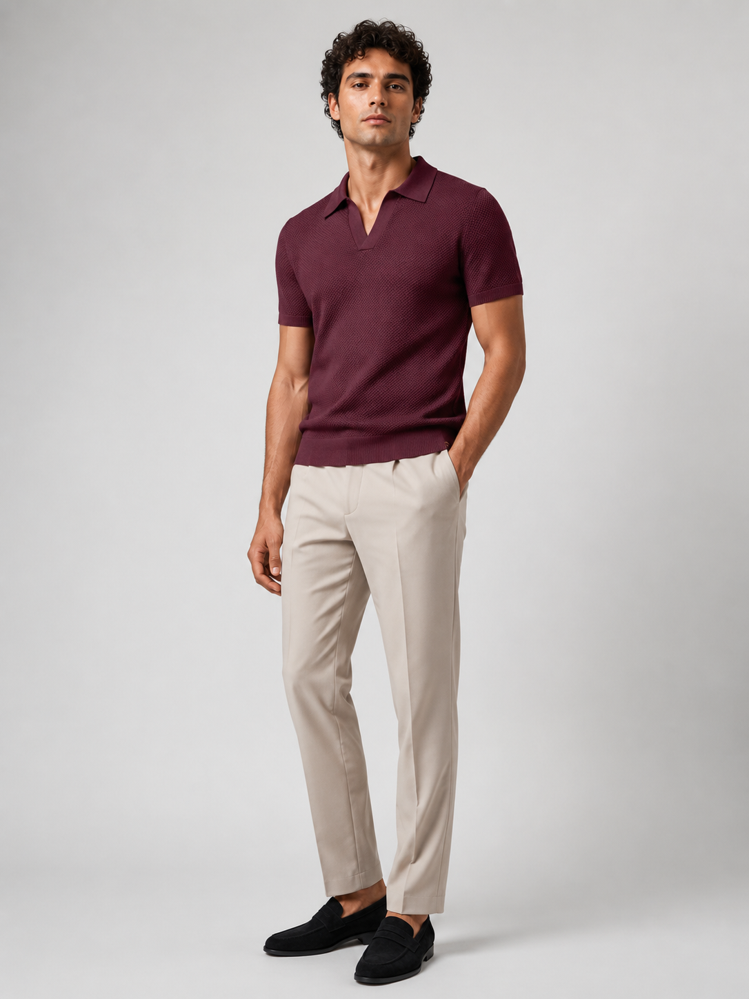 Full-length studio view of model in burgundy knit polo, beige trousers and black suede loafers 23