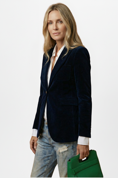 Three-quarter side view of the navy blazer worn open over a white shirt, holding a green bag 5