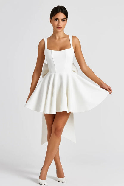 Model in the white dress, front view, holding out the full flared skirt with white heels 3