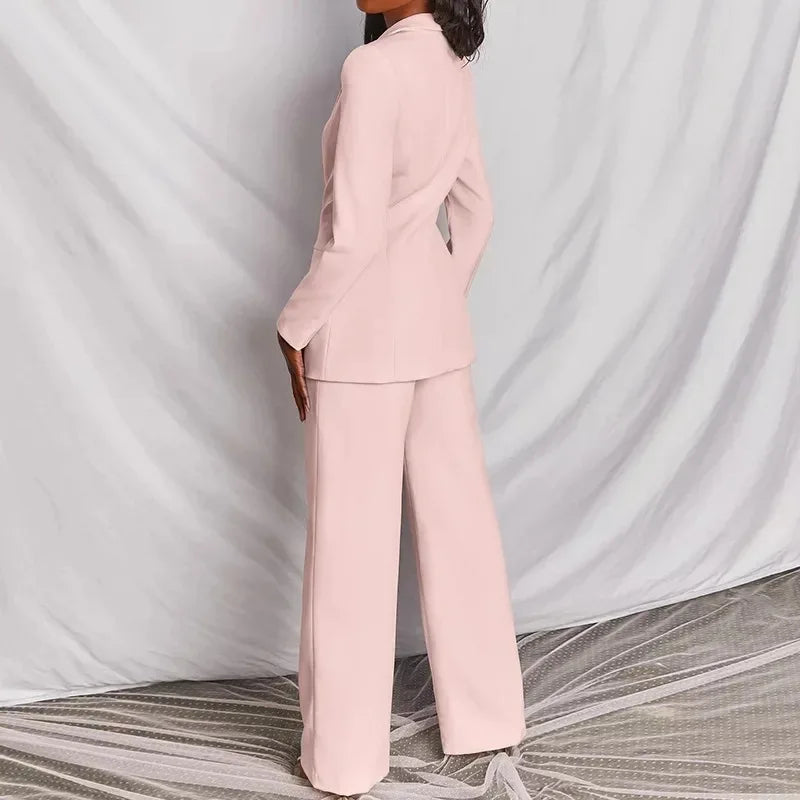 Back view of a pale pink blazer and wide-leg trousers, model turned away from the camera 6