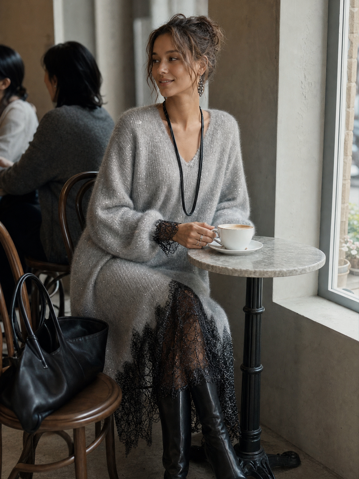 Model seated at a marble café table in the grey dress, holding a coffee cup 4