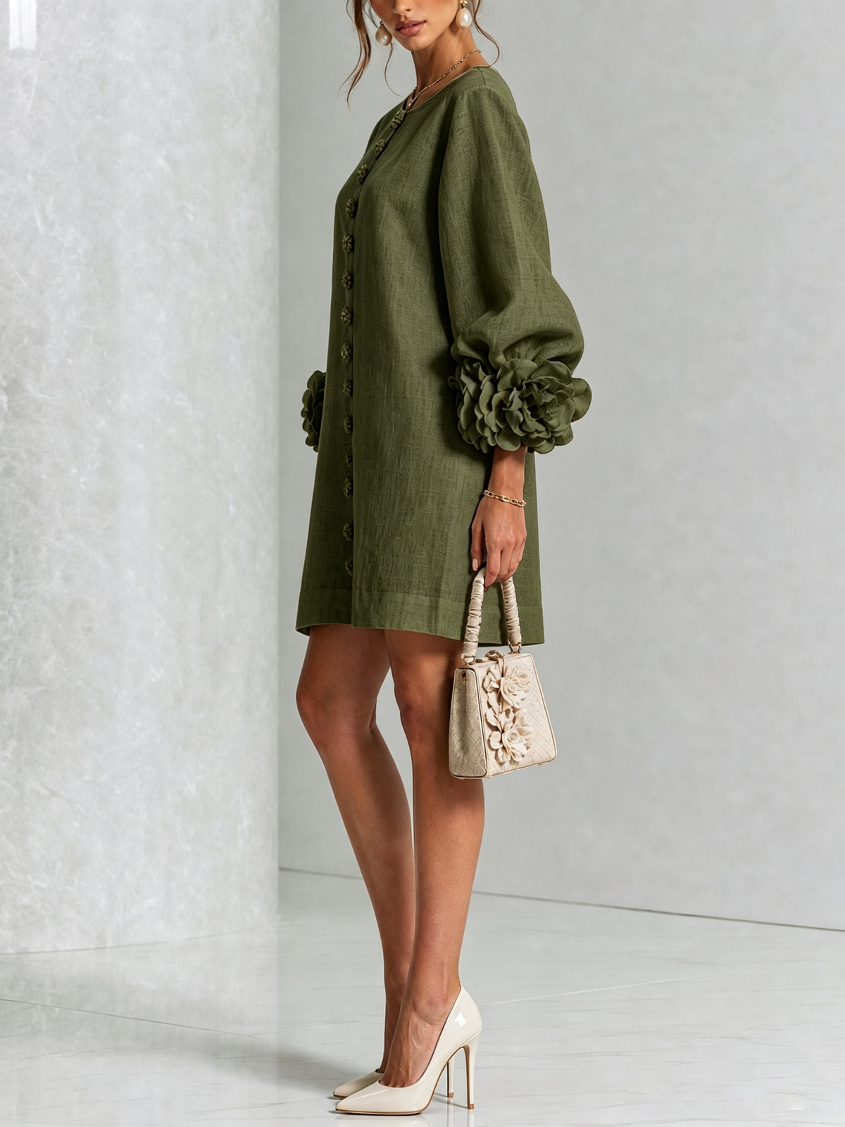 Olive green version in side view, showing the voluminous sleeve with rose cuff, worn with cream heels and a small handbag. 8