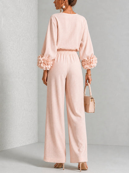 Back view of the blush pink set on a model, showing the smocked waistband and flower cuffs 9