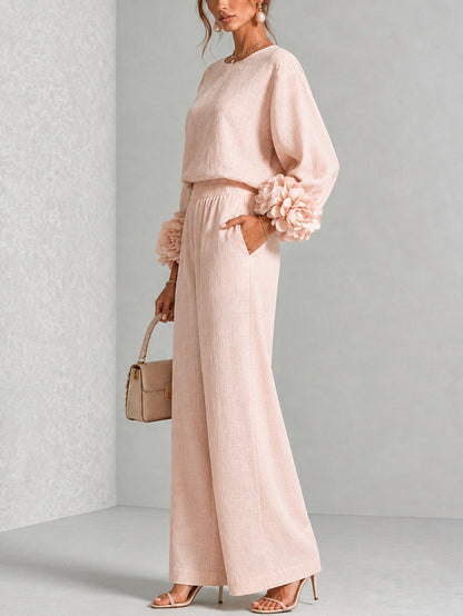 Three-quarter side view of the blush pink set, hand in trouser pocket, with cuff flowers visible 10
