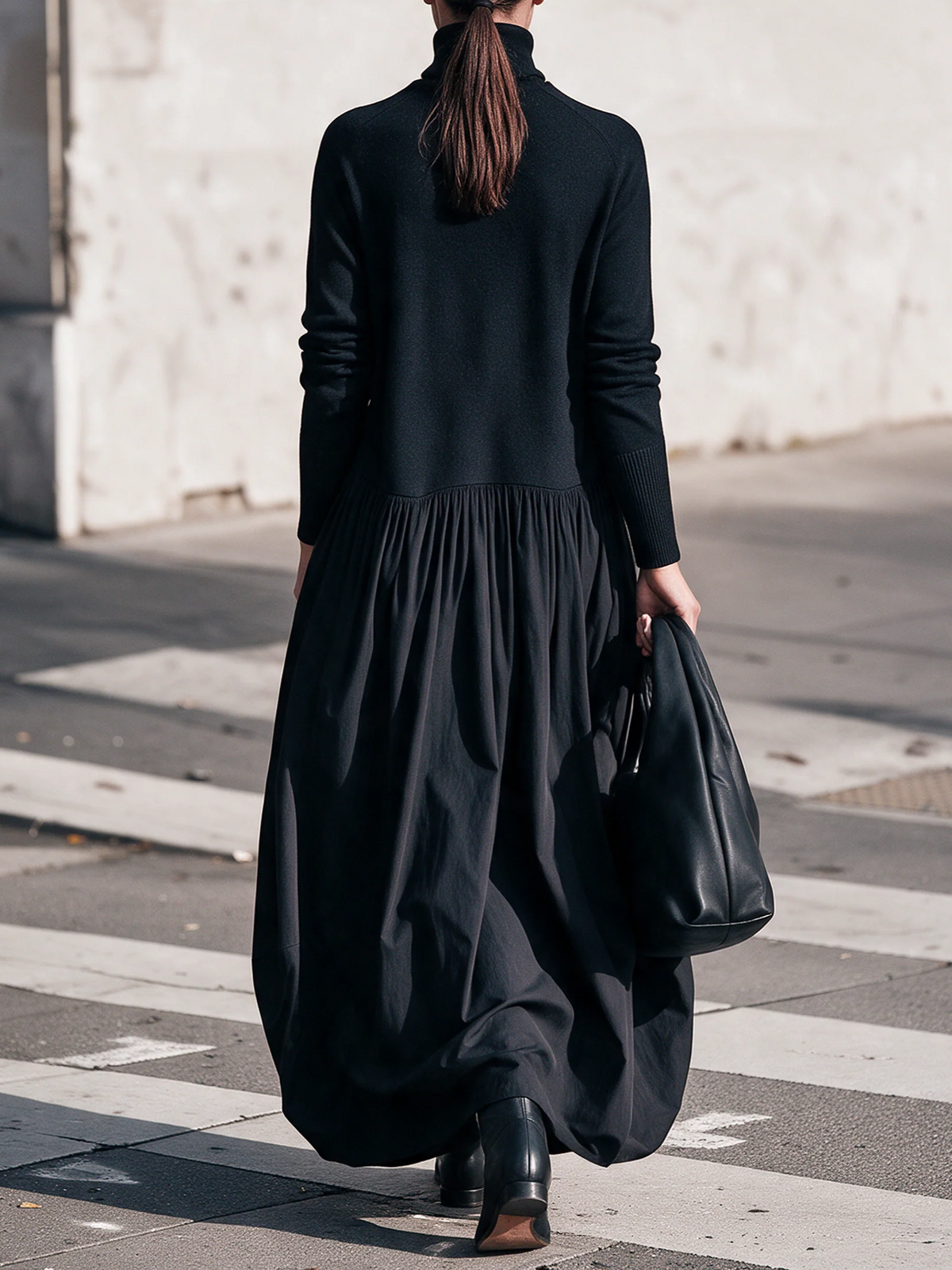 Back view of the black dress on a model with a ponytail, showing the gathered waist seam 3