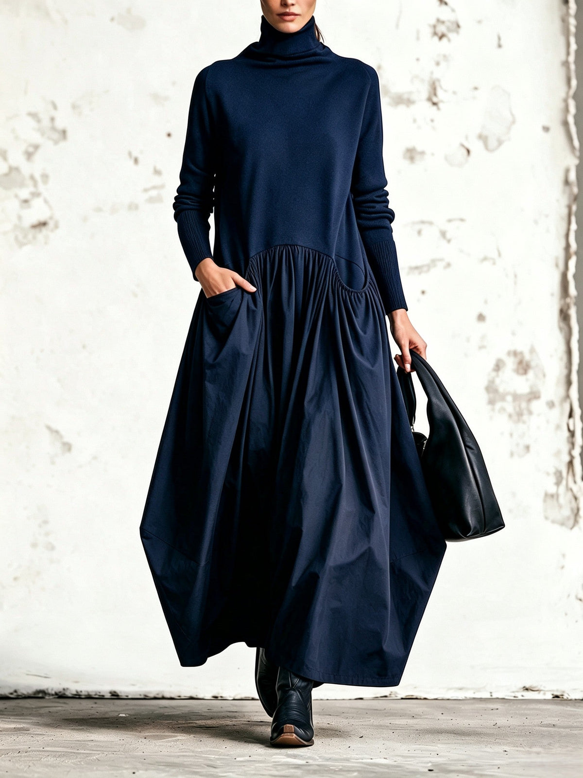 Front view of the dress in navy blue, worn with black boots and a black bag 6