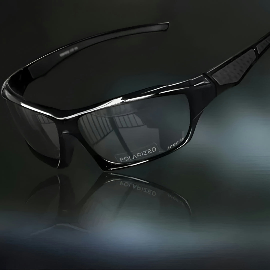 All-black sunglasses with dark grey lenses and subtly textured black arm panels on a dark reflective surface 10