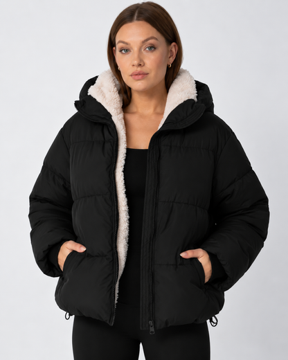 Model wears the black puffer jacket open over a black top, with cream fleece lining and hands in pockets 11