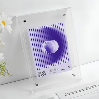 Clear acrylic frame with magnetic corner studs on a white surface, holding a purple striped print, with white flowers nearby. 16