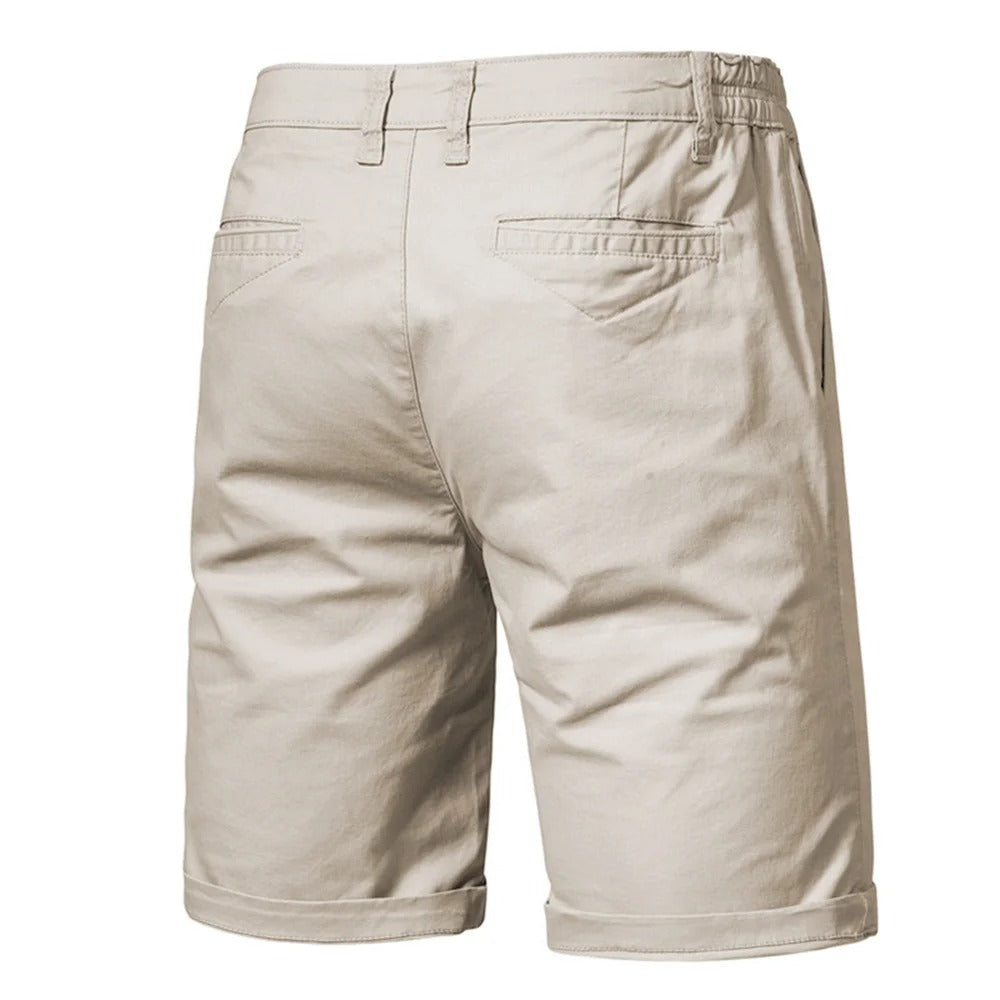 Back view of beige shorts showing two welted back pockets, belt loops and an elasticated waist at the sides. 2