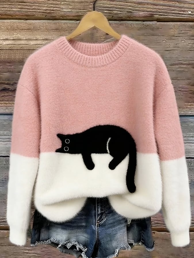 Fluffy jumper with pink upper half, white lower half and black cat patch, on a hanger 2