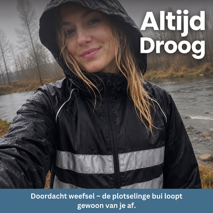 Woman smiling in the rain beside a river, wearing the black hooded jacket with wet droplets on its reflective stripes. 8