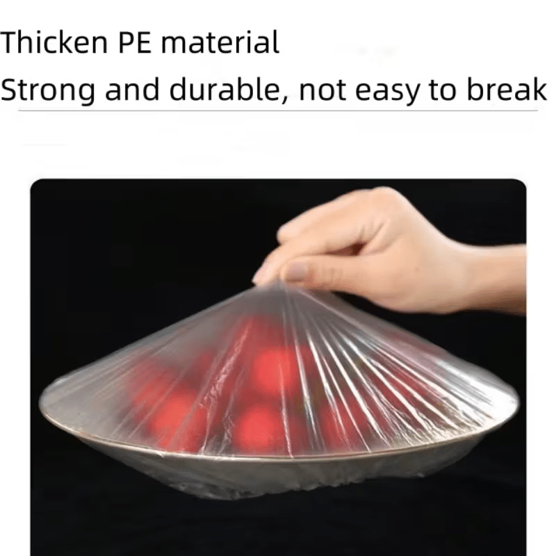 Hand lifting a thin clear cover stretched tight over a shallow dish of red food against a black background. 6