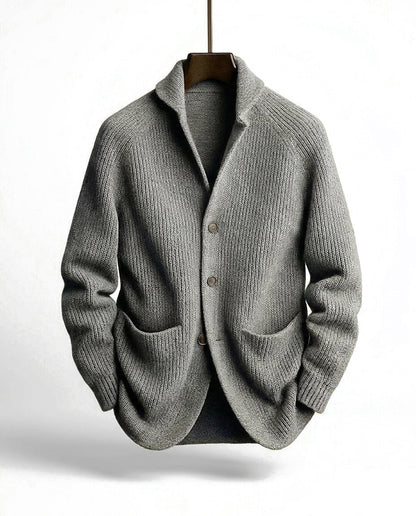 Grey ribbed cardigan on a wooden hanger, front view showing the shawl collar, button placket and two patch pockets. 4