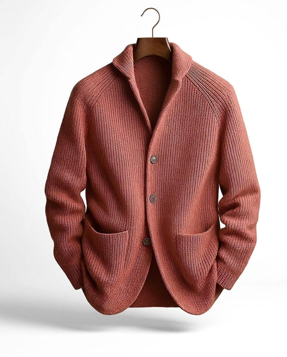 Terracotta-pink ribbed cardigan on a hanger, front view with shawl collar, raglan sleeves, three buttons and two patch pockets. 6