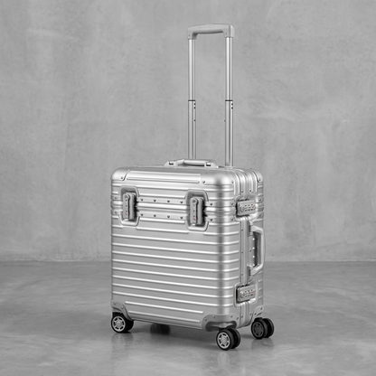 Silver case with extended telescopic handle, side latches and four spinner wheels on a concrete floor 11