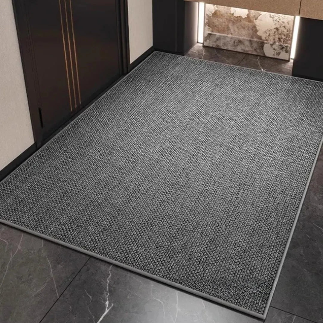 Large grey woven-texture mat with a plain border laid in a dark entrance hallway 3