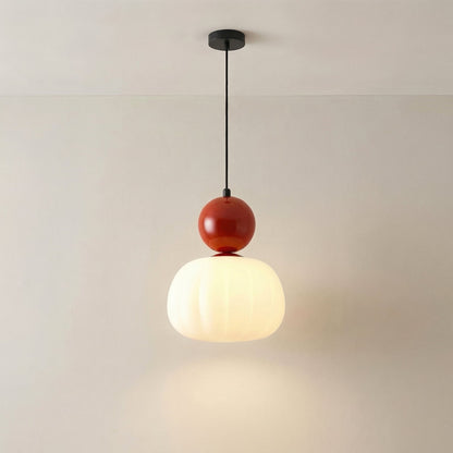 Single pendant with a red glossy cap and fluted opal shade, lit against a plain wall 7