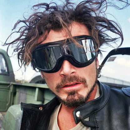 Windswept man in a black leather jacket wearing the goggles with mirrored dark lenses over his eyes. 3