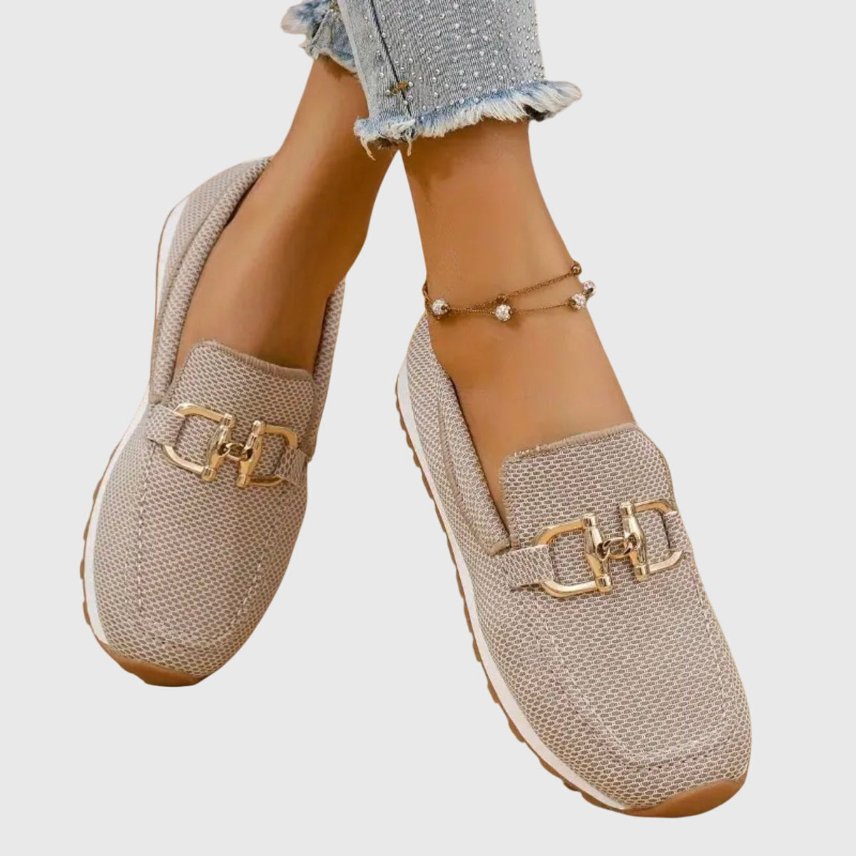Beige mesh loafers worn with feet crossed, showing the gold buckle and white sole from above 5