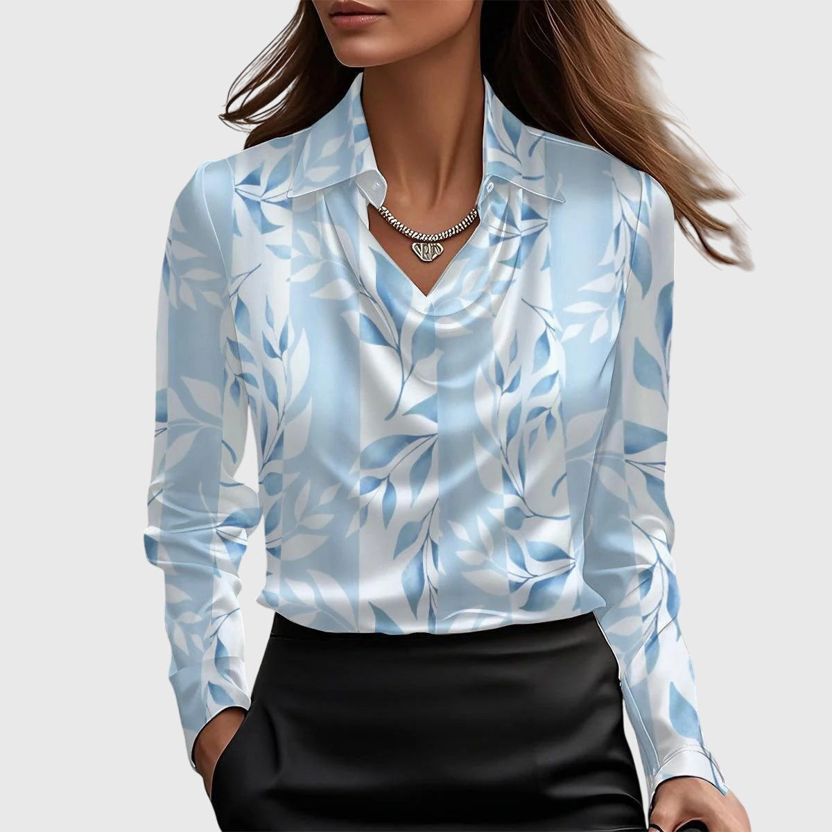 Model wearing the cowl-neck blouse in a white and light blue leaf print, with a pointed collar and long sleeves. 5