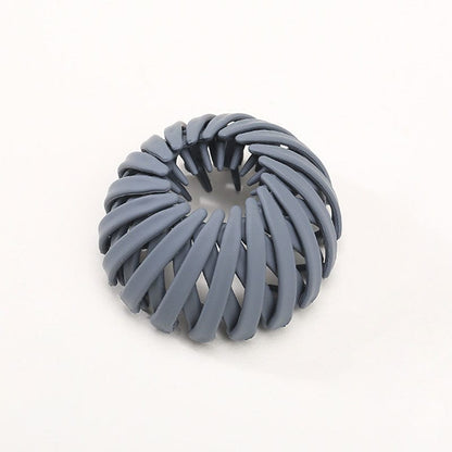 Single matte blue-grey spiral clip, shown open and ring-shaped with its inner teeth visible against a plain background. 6