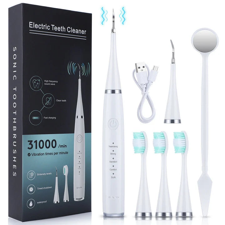 White cleaner set laid out beside its black box: scaler handle, charging cable, scaler head, three brush heads and a dental mirror. 4