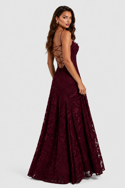 Back view of a deep burgundy lace gown on a model, showing criss-cross lace-up back and flared skirt. 3