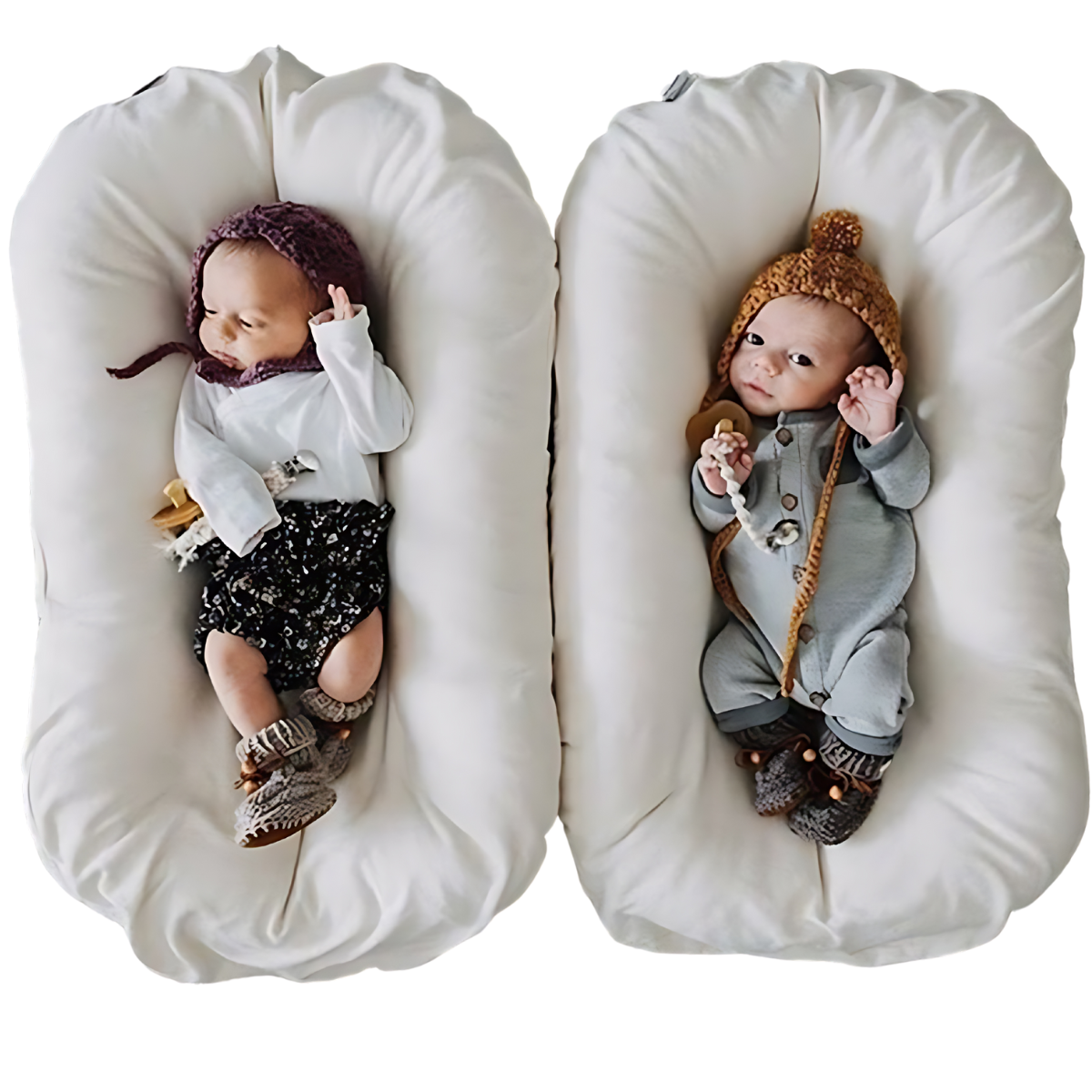 Two newborns in knitted hats and booties rest side by side in two cream nests 5