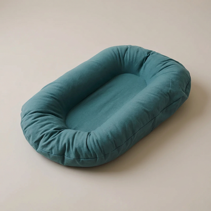 Empty teal oval lounger with raised padded sides, seen from above at an angle 1