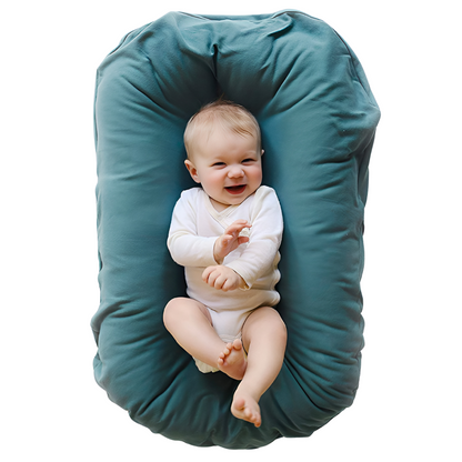 Smiling baby in a white bodysuit lying in a teal lounger, seen from above 2