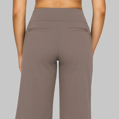Back view of the taupe trousers showing the wide waistband, centre seam and two narrow welt pockets. 4