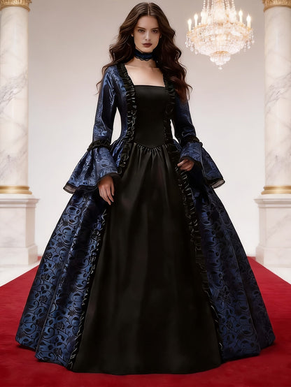 Model wearing the navy and black gown with ruffled front panel and lace choker on a red carpet beneath a chandelier. 2