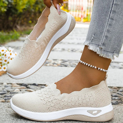 One beige slip-on held up by hand to show the inside, the other worn on foot with a beaded anklet 9