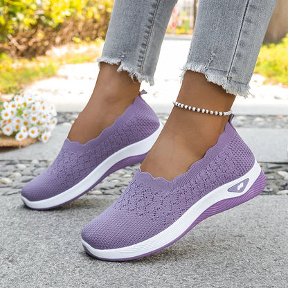 Purple knit slip-on shoes with white midsole and scalloped collar, worn with frayed jeans and a beaded anklet 19