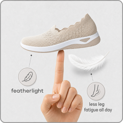 Beige knit slip-on balanced on one fingertip beside a white feather, illustrating how light the shoe is 3