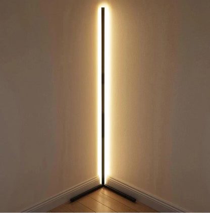Close view of the lamp tucked into a room corner, glowing warm white along its full height 12