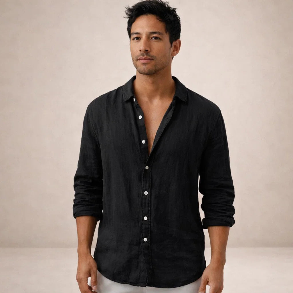 Model facing the camera in a black linen shirt with white buttons, open collar and sleeves rolled up. 10